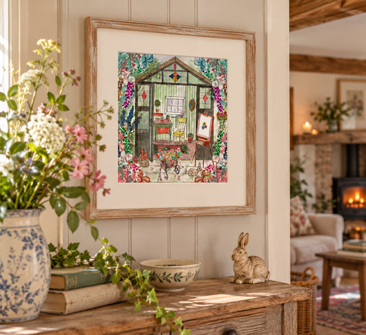 A framed art print depicting a whimsical garden greenhouse scene with colorful flowers and characters, styled on a wooden console table in a cozy, sunlit living room.