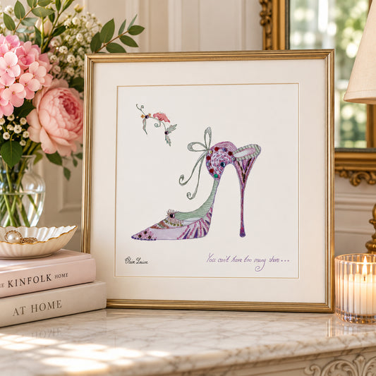 A framed art print featuring a purple and green high-heeled shoe illustration with a small bird and the text 'You will love her someday.
