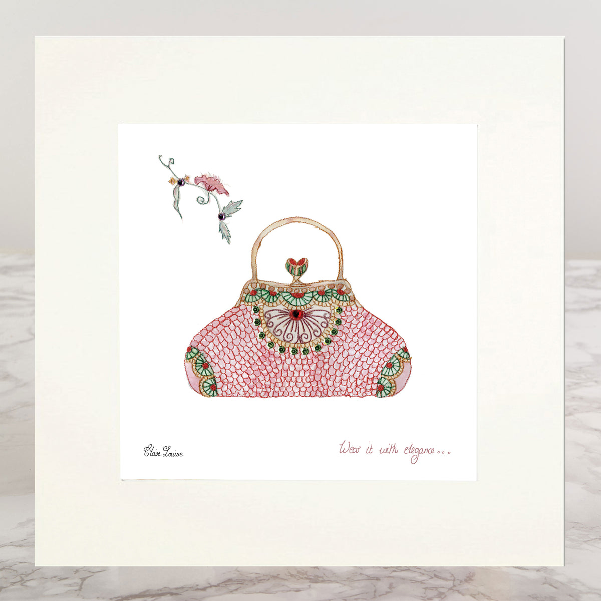 A square art print featuring a hand-drawn pink purse with green and gold ornamental details, displayed on a white mat board over a light gray marble surface.