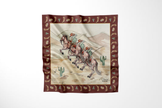 A square silk scarf featuring a western desert illustration with three cowboys, cacti, and a brown border patterned with small motifs, shown against a plain white background.