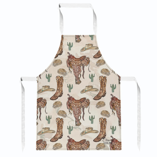 A white bib apron with a cowboy-themed print featuring brown leather boots, saddles, cowboy hats, cacti, and horseshoes on a cream background.
