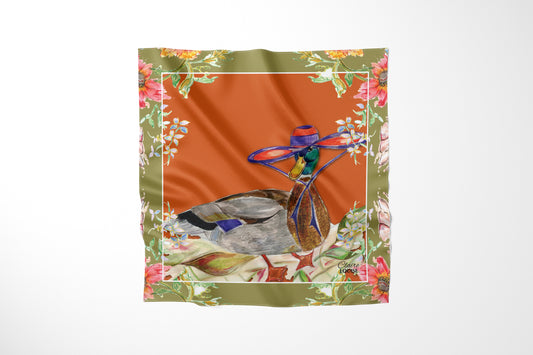 Whimsical Duck Scarf by Claire Louise, a mallard in a wide-brimmed purple hat on burnt orange with an olive floral border