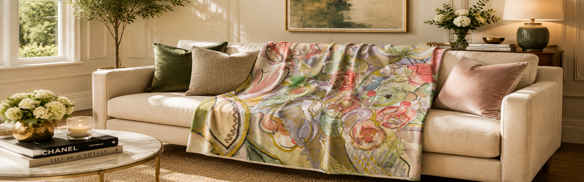Decorative blanket with floral pattern on a beige sofa in a living room.